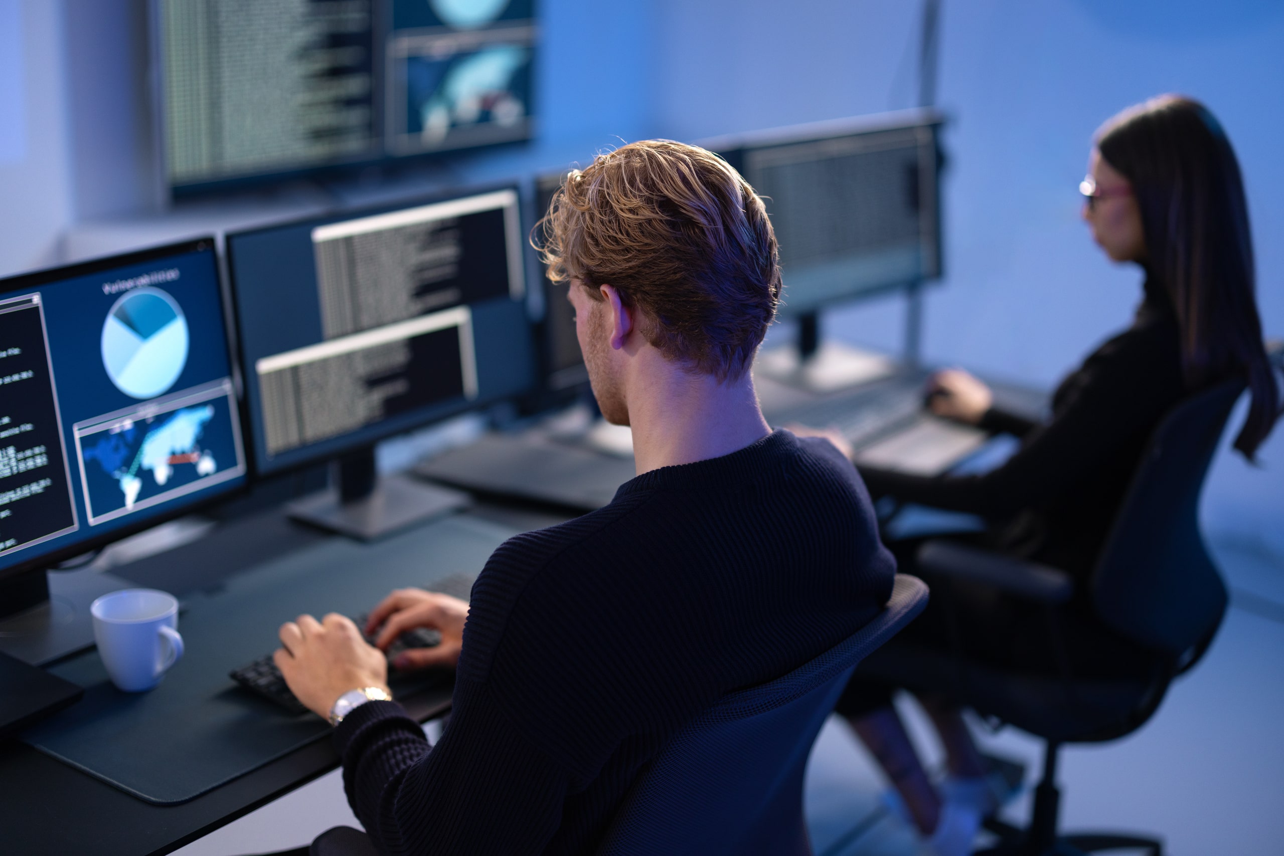 Profesionales Especializados En Identificación De Vulnerabilidades En El Análisis De Riesgos Financieros Trabajando Con Sistemas De Monitoreo Avanzados Equipo de analistas de ciberseguridad financiera trabajando en estación de trabajo con múltiples monitores mostrando gráficos de datos y mapas mundiales para la identificación de vulnerabilidades en el análisis de riesgos financieros, en un entorno de oficina moderna con tecnología avanzada de monitoreo y análisis.